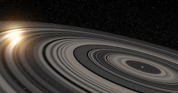 Tak można wyobrażać sobie pierścienie wokół planety J1407b. Rys. Ron Miller /RMF24
