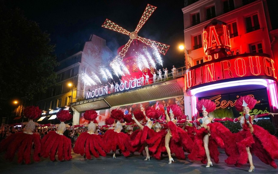 Tancerki Moulin Rouge występują pod nowo zamontowanymi czerwonymi skrzydłami słynnego wiatraka w Paryżu /DIMITAR DILKOFF /East News/AFP