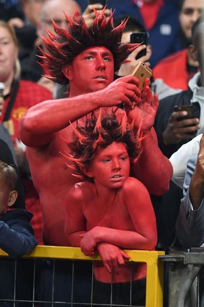 Tata i syn - kibice MU - na trybunach stadionu Old Trafford.  MU zwany jest Czerwonymi Diabłami /AFP