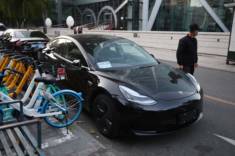 Tesla Model 3 na tle salonu Tesli w Pekinie w Chinach. /Greg BAKER /AFP