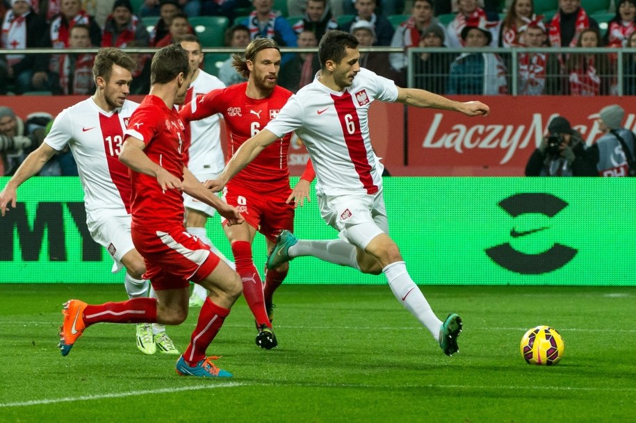 Tomasz Jodłowiec przed Szwajcarami Stevem Von Bergenem (w środku) i Michaelem Langiem. Z lewej - Maciej Rybus /Maciej Kulczyński /PAP