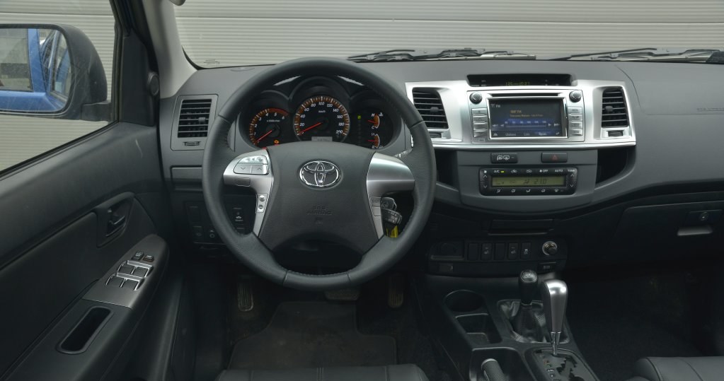 Toyota Hilux 3.0 D-4D 171 KM SR5 A/T 4x4: deska rozdzielcza może nie zachwyca, ale jest ergonomiczna i wykonana solidnie. Fabryczną nawigację można sobie darować – jest zbyt droga, jak na to, co oferuje. Jej plus to wbudowana kamera cofania. /Motor