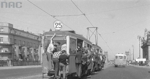 Tramwaj przed mostem Poniatowskiego z pasażerami uwieszonymi na tak zwane "winogrono" /Z archiwum Narodowego Archiwum Cyfrowego