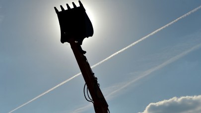 Trzech panów w łyżce koparko-ładowarki. Nie licząc taczek