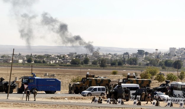 Tureccy żołnierze stoją na granicy z Syrią. W oddali miasto Kobane /SEDAT SUNA (PAP/EPA) /PAP/EPA