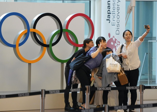 Turyści robią sobie selfie z pomnikiem Kręgów Olimpijskich, ustawionym w terminalu przylotów międzynarodowego lotniska Tokio w Haneda w Japonii /KIMIMASA MAYAMA /PAP/EPA
