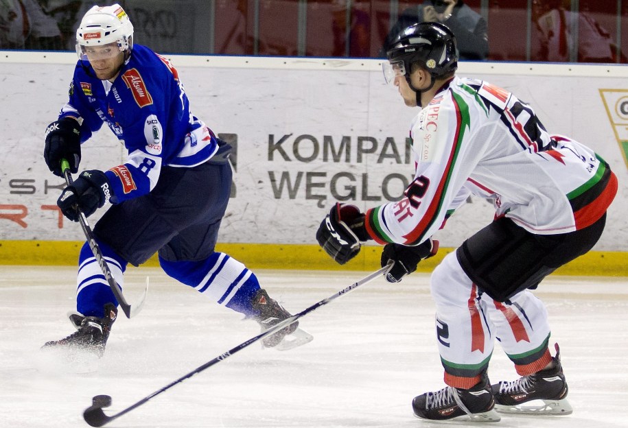Tychy, 10 grudnia 2013. W meczu sezonu zasadniczego hokeista GKS-u Tychy Ladislav Havlik (po prawej) walczy o krążek z Mateuszem Bepierszczem z Aksam Unii Oświęcim /Andrzej Grygiel /PAP