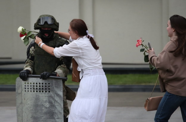 Uczestniczki protestu z kwiatami w rękach pochodzą do żołnierzy /TATYANA ZENKOVICH  /PAP/EPA