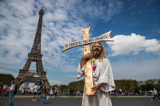 Uczestnik demonstracji przebrany za Jezusa z krzyżem na którym napisane jest "Nie krzyżujcie naszych dzieci" /Christophe Petit-Tesson /PAP/EPA
