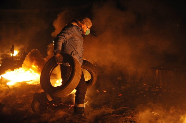 Uczestnik protestów dorzuca do ognia opony /ALEXEY FURMAN /PAP/EPA