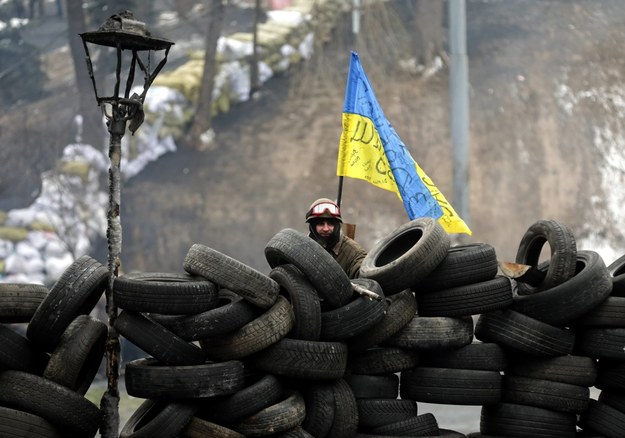 Uczestnik protestów za barykadą z samochodowych opon /MAXIM SHIPENKOV    /PAP/EPA