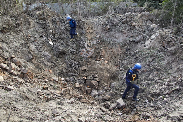 Ukraińscy policjanci w kraterze powstałym w wyniku rosyjskiego ostrzału Charkowa /SERGEY KOZLOV /PAP/EPA