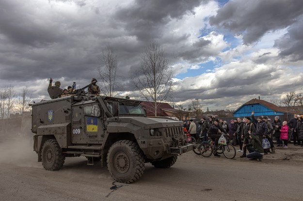 Ukraińscy wojskowi pozdrawiają mieszkańców Trościańca oczekujących w kolejce na pomoc humanitarną /ROMAN PILIPEY /PAP/EPA