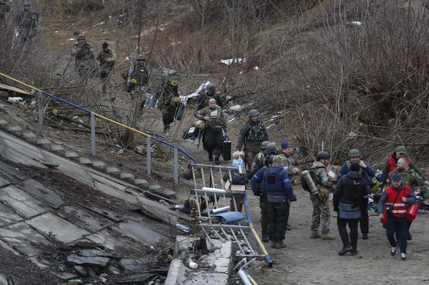Ukraińscy żołnierze chodzą po zniszczonym moście przy wjeździe do miasta Irpin pod Kijowem /ATEF SAFADI  /PAP/EPA