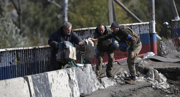 Ukraińscy żołnierze pomagają mężczyźnie w wyzwolonym Kupiańsku w obwodzie charkowskim /ATEF SAFADI  /PAP/EPA