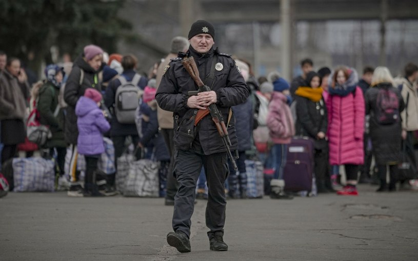 Ukraiński policjant pilnujący ludzi czekających na ewakuację z Kijowa /AP/Associated Press/East News /East News