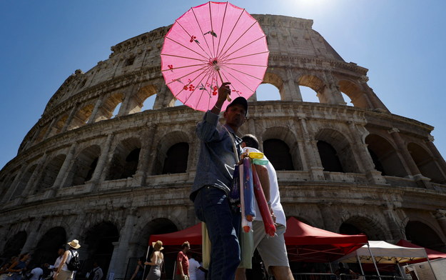Uliczny sprzedawca parasoli na tle Koloseum podczas fali upałów w Rzymie na zdjęciu z 29 lipca br. /Fabio Frustaci /PAP/EPA