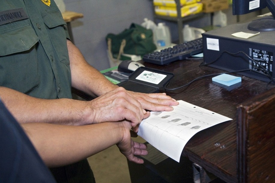 USA. Pobieranie odcisków palców przed deportacją nielegalnego imigranta /East News