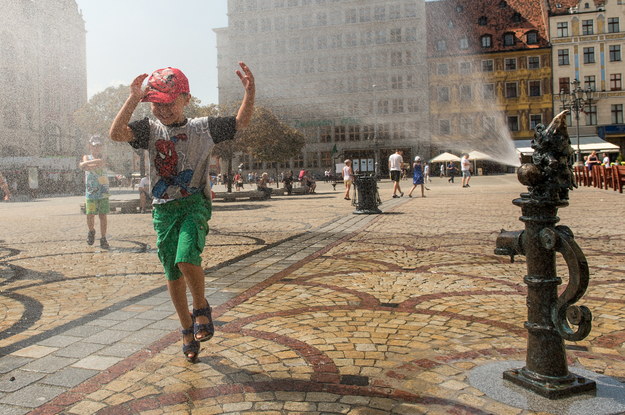 W czasie upałów wrocławianie i turyści mogą skorzystać z dobrodziejstw kurtyny wodnej na Rynku Głównym /Maciej Kulczyński /PAP