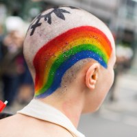 Kobieta z wymalowaną tęczą na głowie. 