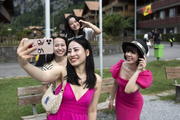 Wietnamscy turyści robiący sobie selfie w szwajcarskiej miejscowości Isetwald /PETER KLAUNZER /PAP/EPA