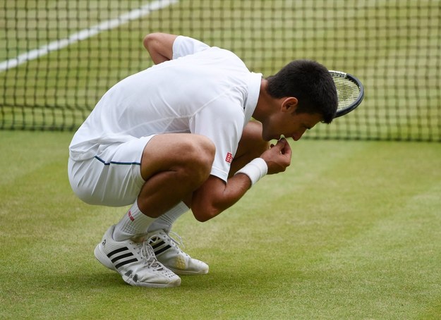 Wimbledon 2015: Novak Djoković je źdźbło trawy po zwycięstwie /FACUNDO ARRIZABALAGA /PAP/EPA