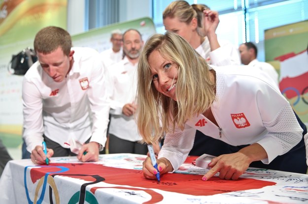 Windsurferka Małgorzata Białecka podpisuje flagę olimpijską /Rafał Guz /PAP