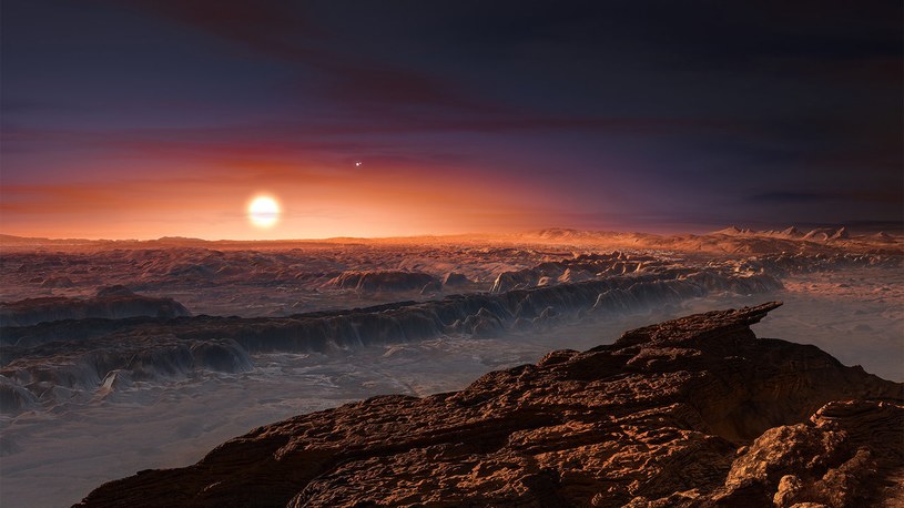 Wizja artystyczna powierzchni planety Proxima b, orbitującej wokół czerwonego karła Proxima Centauri. W tle widoczne pozostałe dwie gwiazdy tego układu wielokrotnego Alfa Centauri AB /materiały prasowe