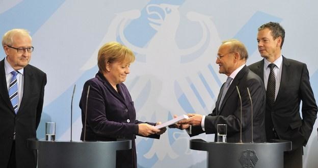 Wolfgang Franz, prezes Rady Ekspertów Gospodarczych przekazuje dokumenty kanclerz Angeli Merkel /AFP