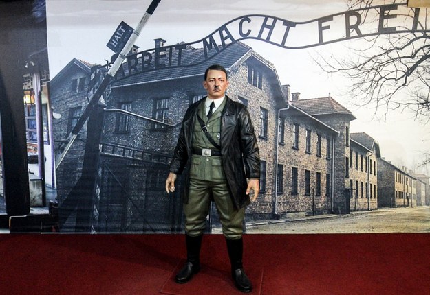 Woskowa figura Adolfa Hitlera przed zdjęciem przedstawiającym bramę do obozu Auschwitz-Birkenau /BOY TRIHARJANTO /PAP/EPA