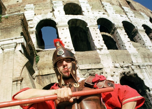 Współczesny legionista przed rzymskim Koloseum pozuje turystom do zdjęć /Adam Hawałej /PAP