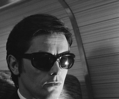 Z racji swojej popularności Delon zatrudniał wielu ochroniarzy. Jednym z nich był urodzony w Belgradzie Stevan Marković, który na tyle dobrze dogadywał się ze swoim szefem, że szybko przestał być ochroniarzem, a zaczął być współorganizatorem jego wystawnych i szalonych przyjęć. Marković znany był ze swojego zamiłowania do hazardu. Dlatego pewnego razu postanowił zaryzykować. W sypialniach willi należącej do Delona, przed rozpoczęciem przyjęcia, porozstawiał aparaty fotograficzne. 

Jedna z "prywatek" w domu aktora była szczególnie huczna, dlatego Markovicowi udało się zebrać spory materiał, którym zaczął szantażować "bohaterów" zdjęć. Wśród osób uwiecznionych na fotografiach był zarówno sam Delon, jak i jego przyjaciel Marcantoni. Asem w rękawie były jednak intymne fotograf