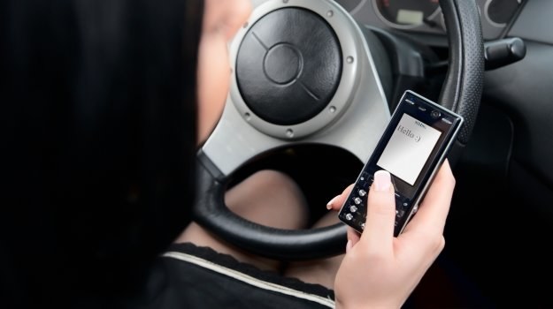 Za korzystanie podczas jazdy z telefonu, wymagające trzymania go w ręku, grozi 200 zł mandatu i 5 punktów karnych. /Shutterstock