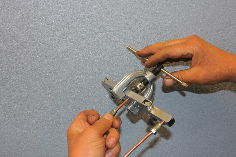 Zakończenia przewodu w odpowiednim kształcie zarabiane są w niewielkiej prasie ręcznej. /Motor