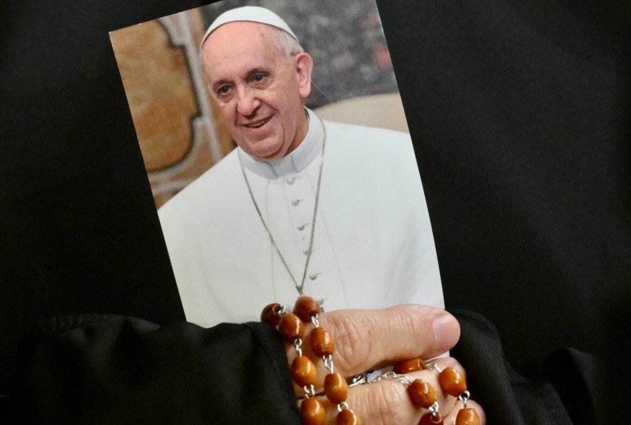 Zakonnica trzyma zdjęcie papieża Franciszka podczas wieczornej modlitwy w jego intencji na placu św. Piotra w Watykanie /ALESSANDRO DI MEO    /PAP/EPA