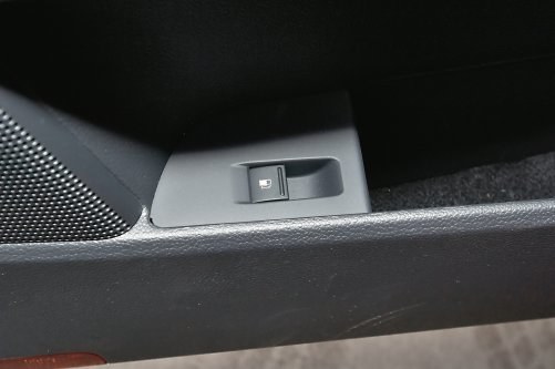 Zamiast tradycyjnej dźwigienki przy fotelu albo zamka na kluczyk, w wielu VW zatrzask klapki zwalnia się przyciskiem w kieszeni drzwi. /Motor