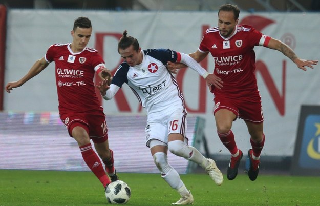 Zawodnicy Piasta Gliwice Tom Hateley (P) oraz Patryk Dziczek (L) i Kamil Wojtkowski (C) z Wisły Kraków podczas meczu 14. kolejki piłkarskiej Ekstraklasy / 	Andrzej Grygiel    /PAP