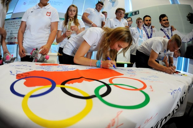 Zawodnicy składają podpisy na fladze olimpijskiej podczas uroczystości wręczenia nominacji oraz złożenia przyrzeczenia przed wyjazdem na II Młodzieżowe Igrzyska Olimpijskie w Nankinie /PAP/Bartłomiej Zborowski /PAP