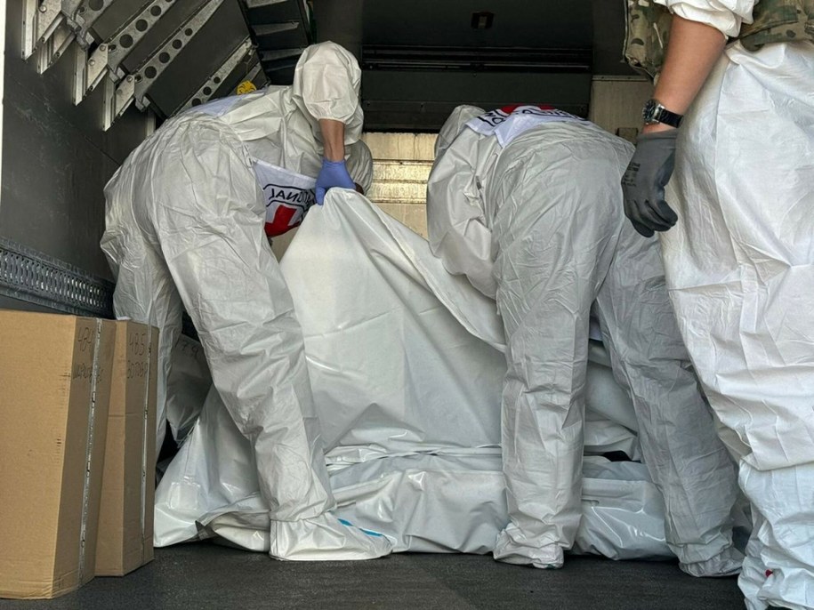 Zdj. poglądowe. Ukraińska Kwatera Koordynacyjna ds. Postępowania z Jeńcami Wojennymi i przedstawiciele Międzynarodowego Czerwonego Krzyża sprawdzają worki na zwłoki żołnierzy podczas wymiany ciał w nieujawnionym miejscu w obwodzie sumskim /HANDOUT/AFP/East News /East News