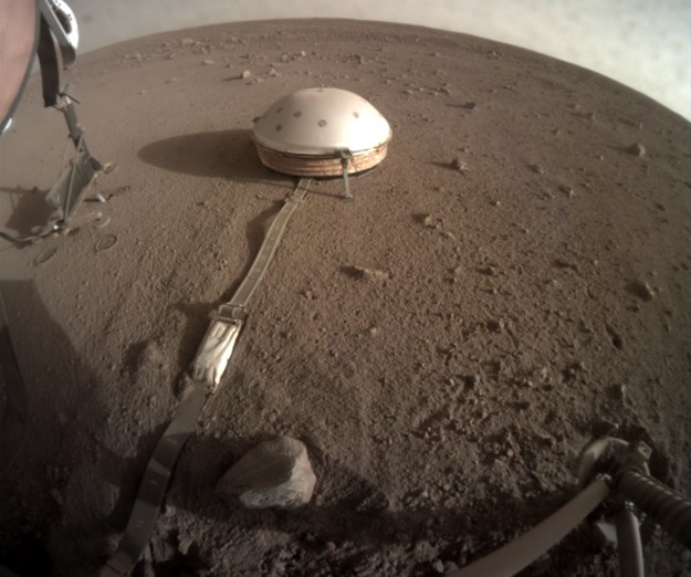 Zdjęcie uniesionej struktury podtrzymujacej (po lewej) i Kreta wbitego w marsjański grunt, wykonane 23.06.2019 roku /NASA/JPL-Caltech /Materiały prasowe