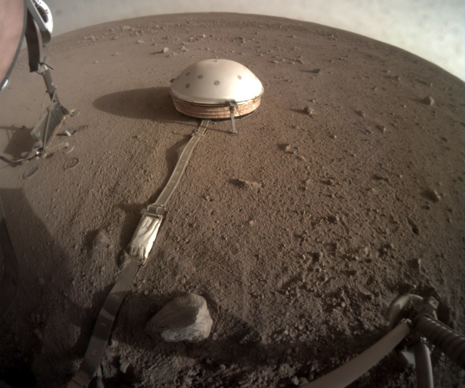 Zdjęcie uniesionej struktury podtrzymujacej (po lewej) i Kreta wbitego w marsjański grunt, wykonane 23.06.2019 roku /NASA/JPL-Caltech /Materiały prasowe