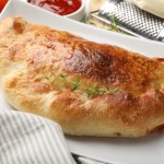 Złocisty i chrupiący pieróg jak pizza. Włosi zajadają się calzone bez opamiętania
