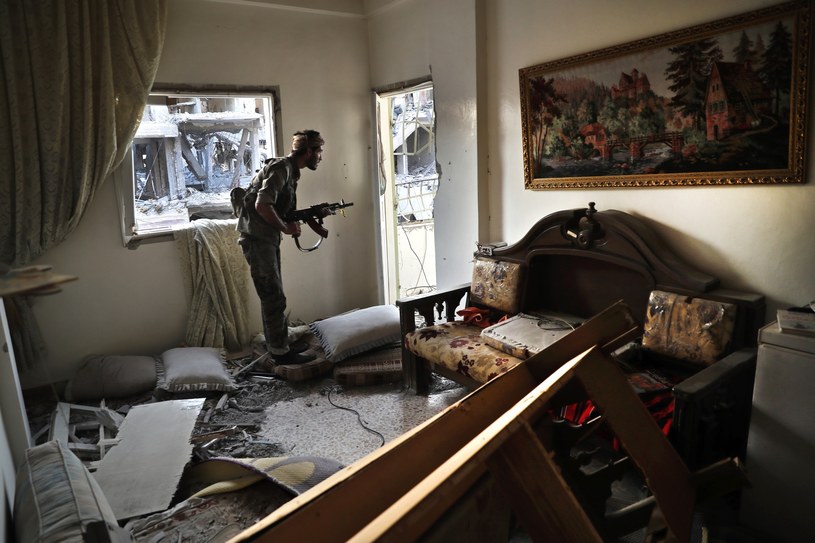 Żołnierz Syryjskich Sił Demokratycznych (SDF) w zniszczonym mieszkaniu na linii frontu w Ar-Rakce w Syrii /AP Photo/Hussein Malla /East News
