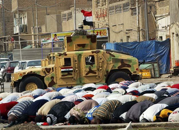 Żołnierze irackiej armii ochraniają modlących się szyitów przed jednym z bagdadzkich meczetów /AFP