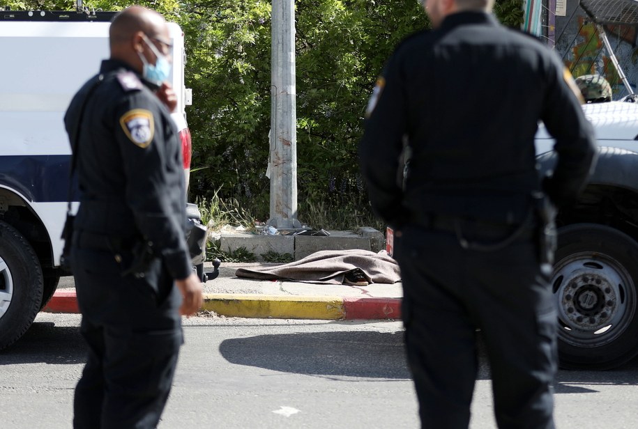 Żołnierze izraelscy stoją w pobliżu ciała Palestynki, która została postrzelona i ranna próbie dźgnięcia izraelskiego mundurowego /ABED AL HASHLAMOUN    /PAP/EPA