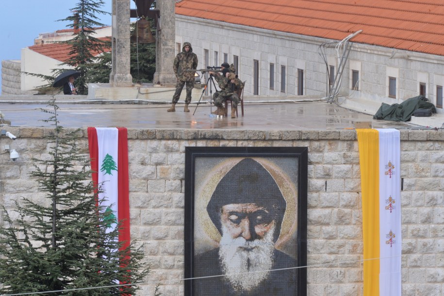 Żołnierze z bronią na klasztorze św. Marona w Annai przed przybyciem papieża. Poniżej wizerunek św. Szarbela /WAEL HAMZEH /PAP/EPA