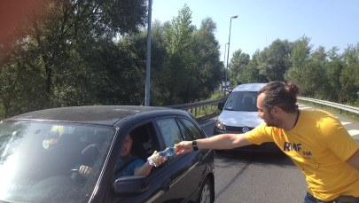 Żółto-niebieski konwój rozdaje wodę na A4 w Krakowie