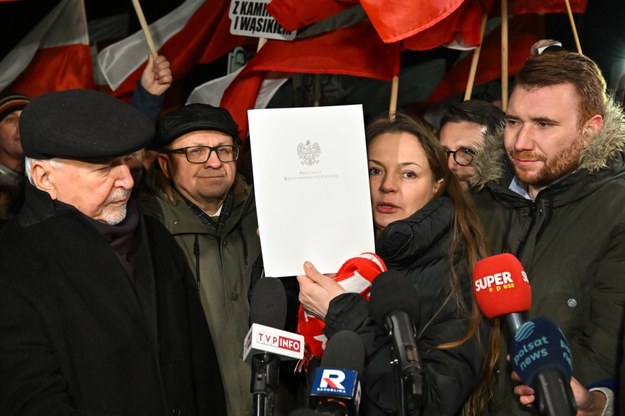 Żona Mariusza Kamińskiego Barbara Kamińska pokazująca z prezydencki dokument o ułaskawieniu i syn Kacper Kamiński. /Piotr Polak /PAP