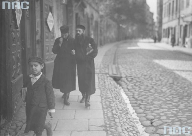 Żydzi podczas spaceru na ul. Świętojerskiej w Warszawie. Na pierwszym planie widoczny żydowski chłopiec z książkami /Z archiwum Narodowego Archiwum Cyfrowego